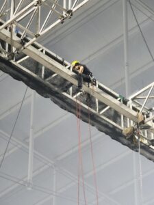 Técnico IRATA trabajando en un estadio de fútbol.